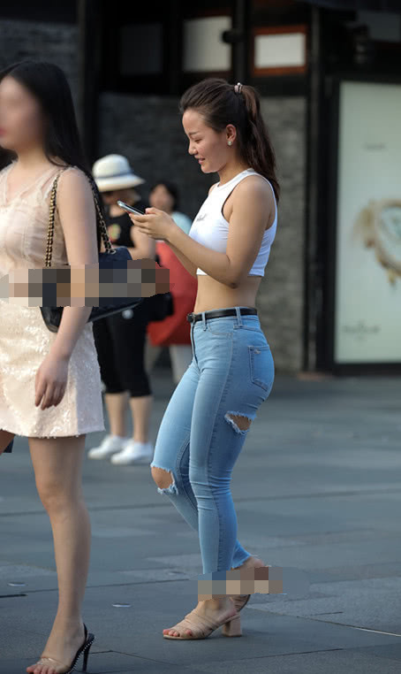 气质小姐姐清爽的紧身牛仔裤展现玲珑有致的线条，街头靓丽的风景