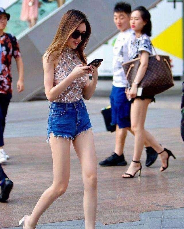 苗条的小姐姐穿着修身牛仔短裤，将小姐姐长腿拉伸的十分修长迷人