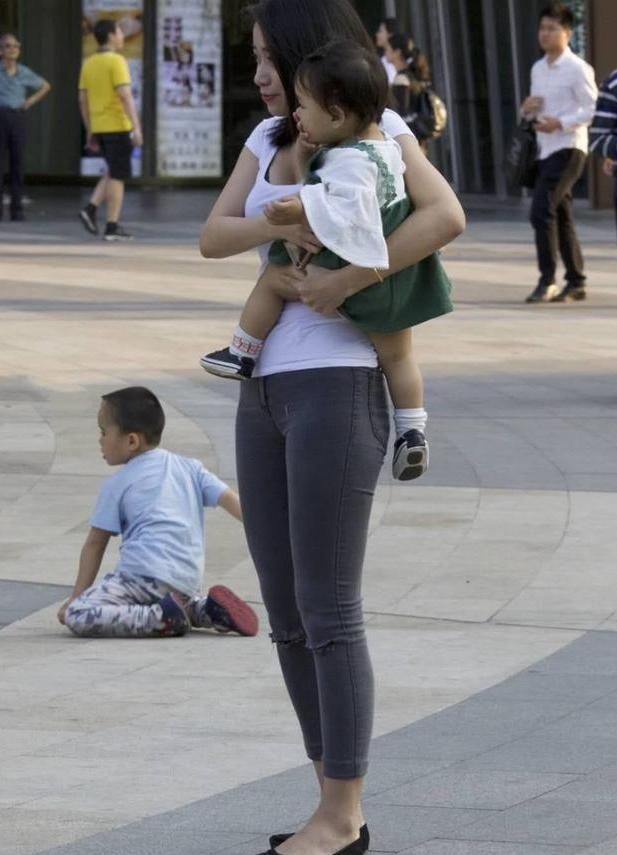 街拍美女：白色的t恤搭配黑色的紧身牛仔裤，辣妈身材很耐看