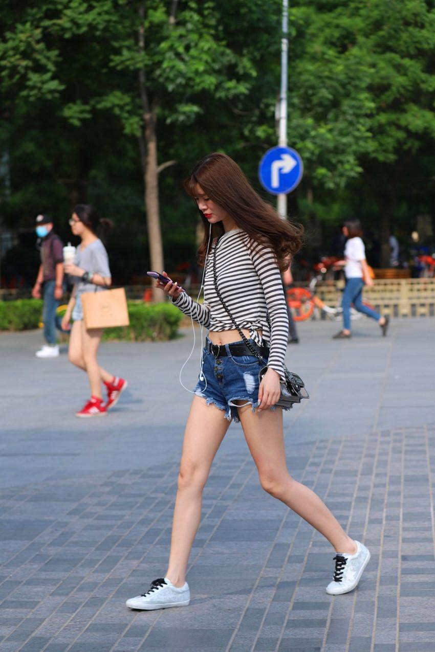 路人街拍，小姐姐身穿浅色破洞牛仔裤，小蛮腰隐隐可现