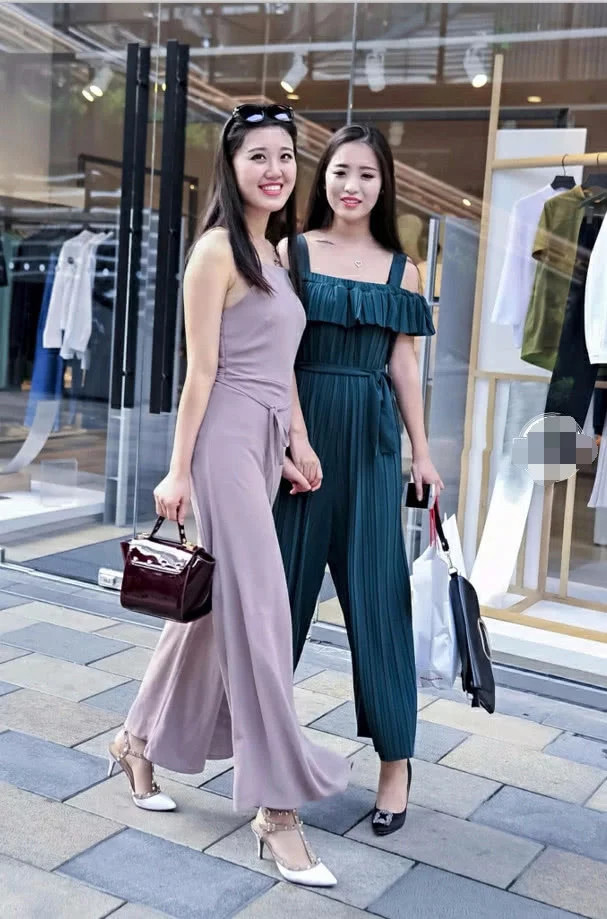 优雅时尚姐妹花漫步街头，修身长裙显凹凸有致身材