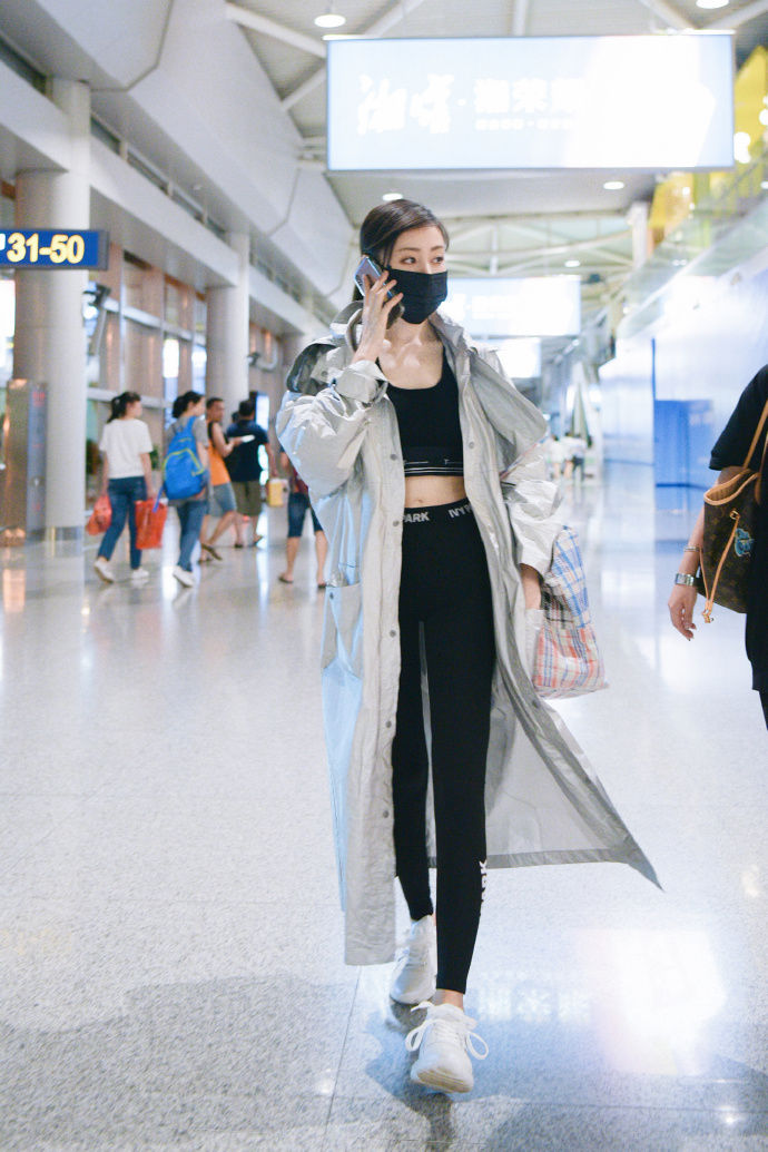 张天爱现身机场 黑色紧身裤外搭银色长款雨衣 尽显大长腿