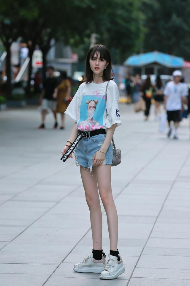 路人街拍，小姐姐身穿一件白色无袖紧身的超短裙，温柔又有女人味