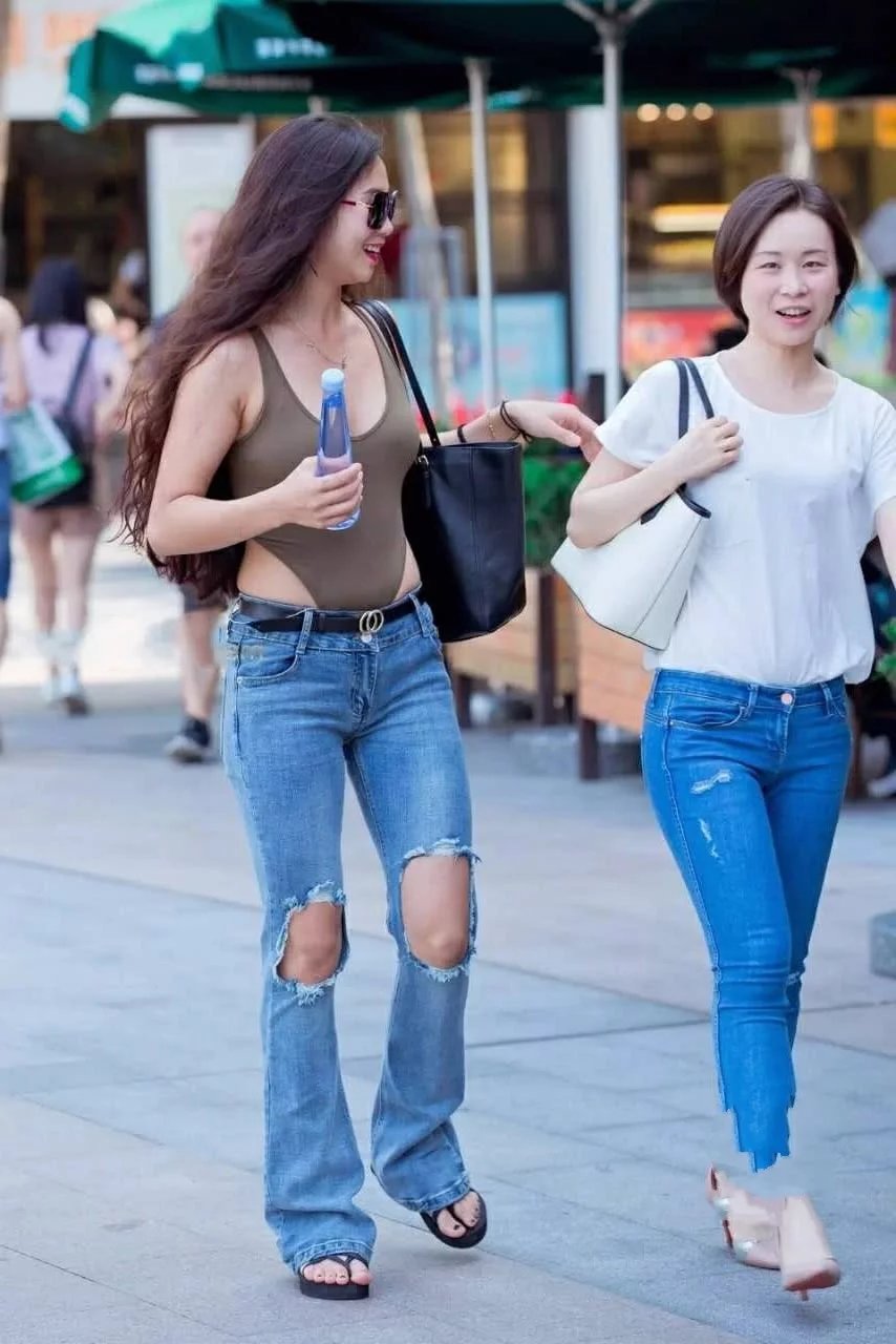 连体泳装外穿的小姐姐吸睛无数，微胖的身材，搭配破洞牛仔裤像小