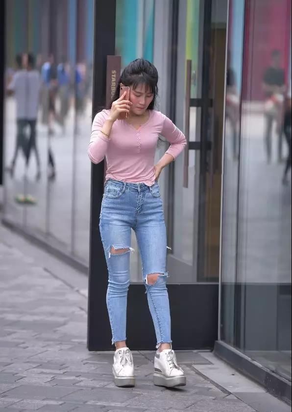 街拍：打着电话，穿牛仔长裤的翘臀性感长发美女