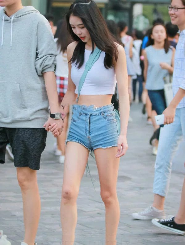 甜美小姐姐露脐装秀出白皙小蛮腰，超短裤裹出浑圆曲线，丸子头俏