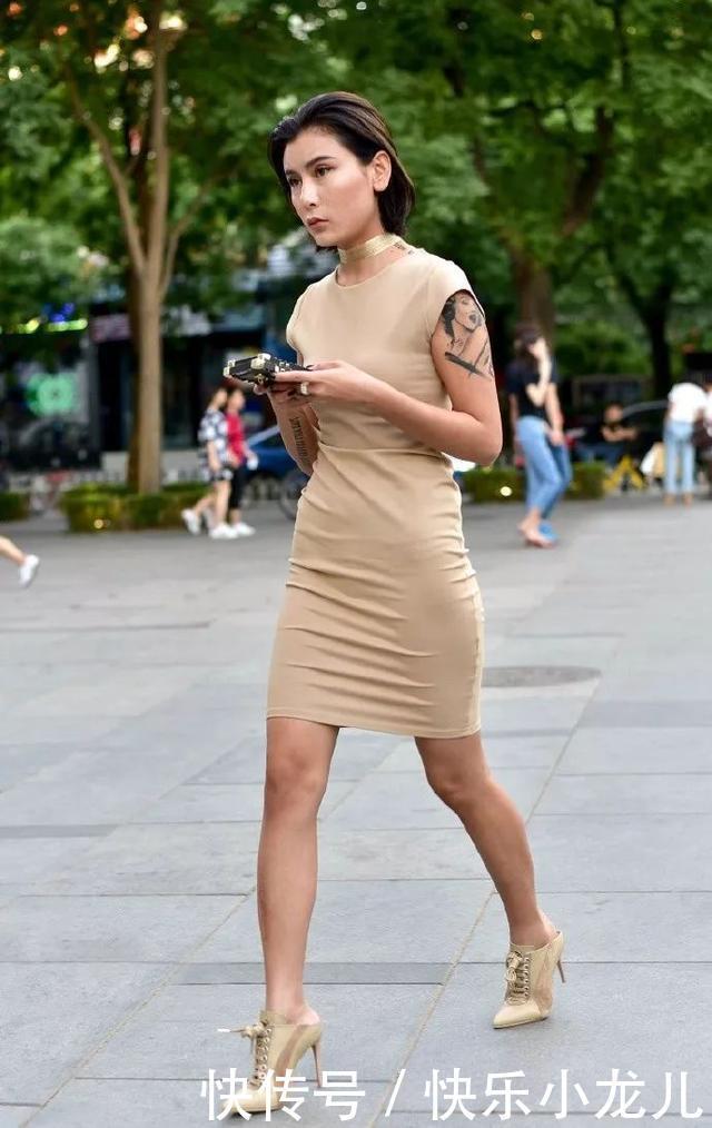  「身上穿着一」街拍美女一件裸色的无袖连衣裙搭配尖头高跟短靴，气质时尚又带着魅力