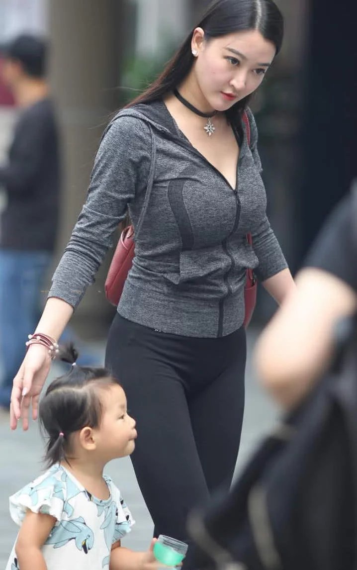 时尚小姐姐带娃逛街，黑色紧身裤裹出曼妙身姿，俏皮的一点很是吸