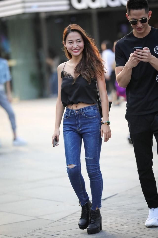 长发美女紧身牛仔裤搭配黑色吊带，娇俏的容颜，气质甜美