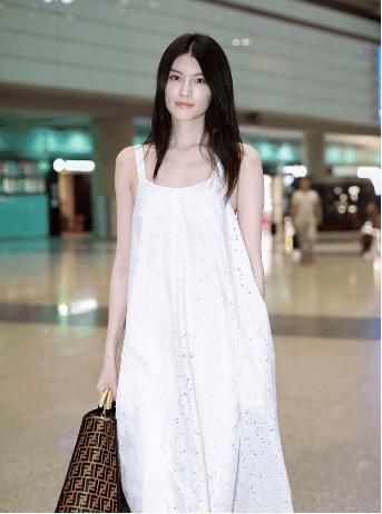 何穗一身白裙亮相机场，长发飘飘，气质动人，校园女神无疑了