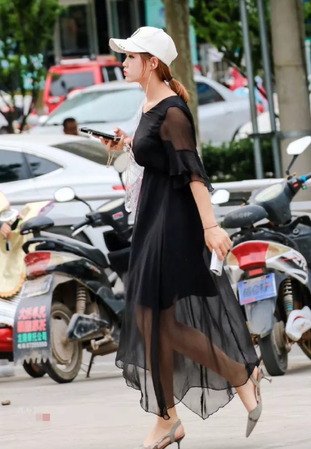 街拍头戴遮阳帽身穿黑色薄纱连衣裙的美女小姐姐