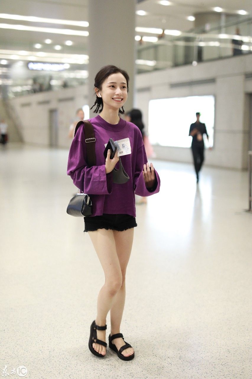 姜梓新穿紫色卫衣搭配黑短裤现身机场，皮肤白皙面带微笑大秀美腿