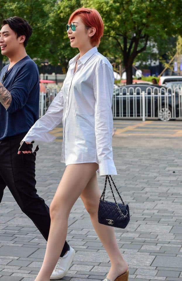 时尚小姐姐只穿一件衬衣就出门了，摇摆的白嫩大腿很吸晴