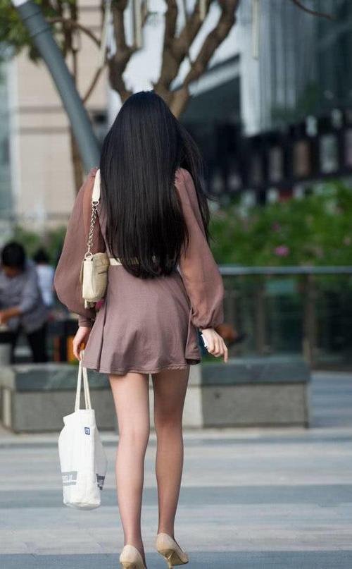 路人街拍，小姐姐身上穿了一件棕色的连衣裙，增添了几分甜美可爱