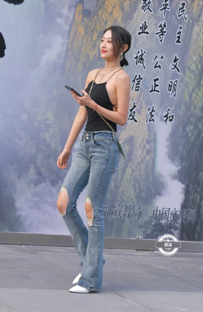 路人街拍，黑色上衣搭配牛仔裤，展示性感好身材，时尚潮流有魅力