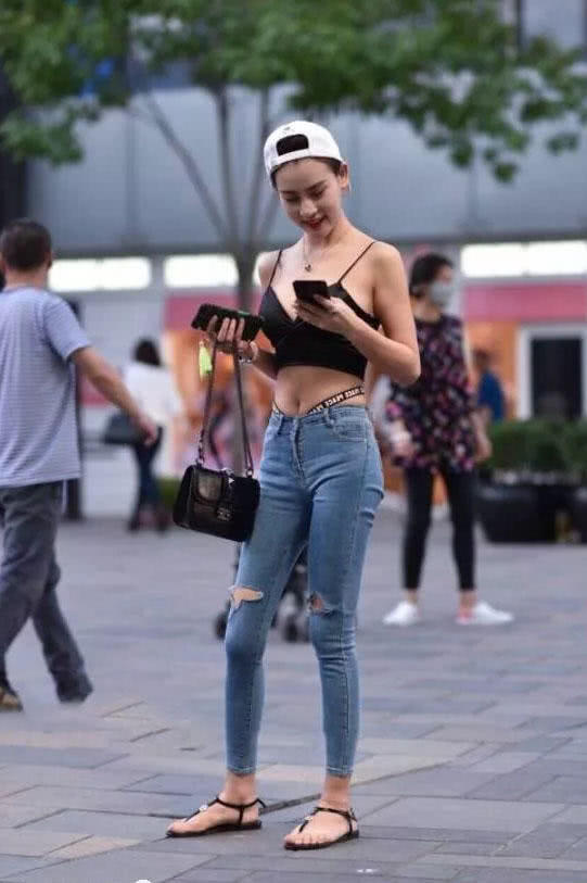 可爱萌妹吊带背心勾勒出凹凸有致的曲线，清爽效果极佳，破洞牛仔