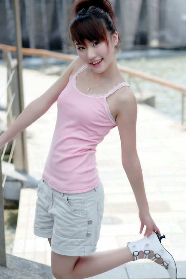 阳光下一个衣着粉色背心的清甜可爱小妹