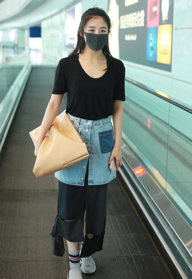 张含韵的时尚真难懂，不仅穿破裙子走机场，还在长裙外面套短裙！
