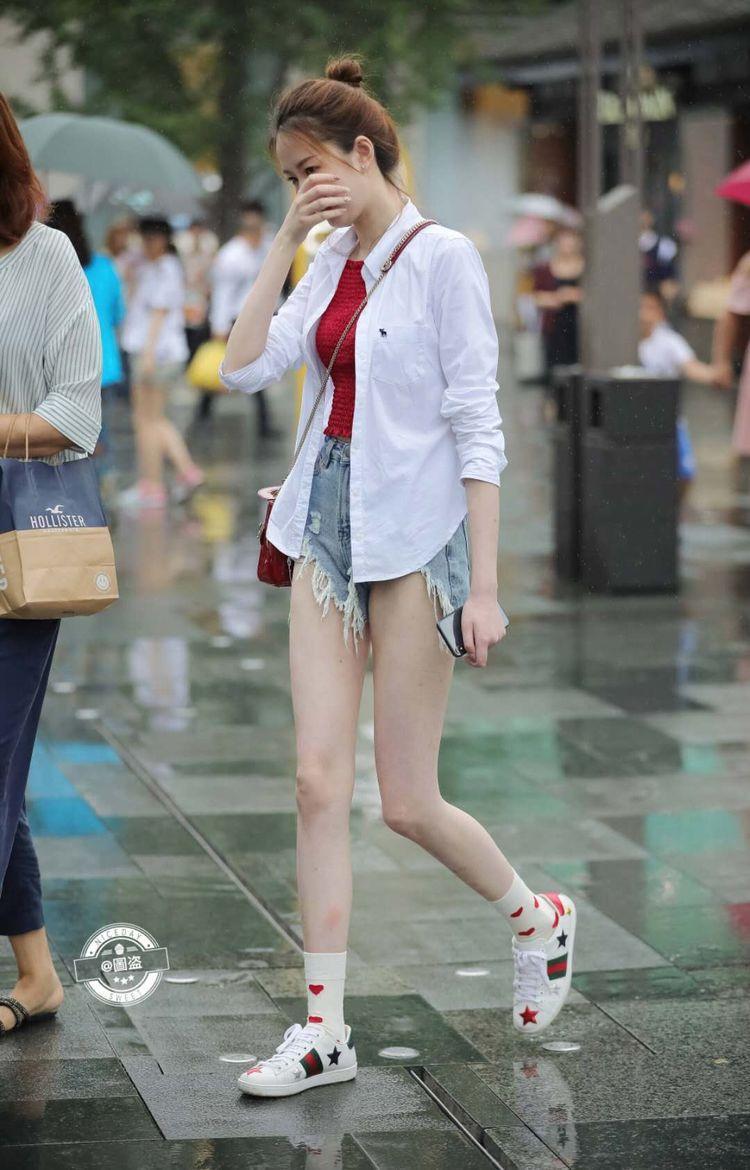 路人街拍，小姐姐在雨中漫步，看上去非常的简约清新，让人难忘