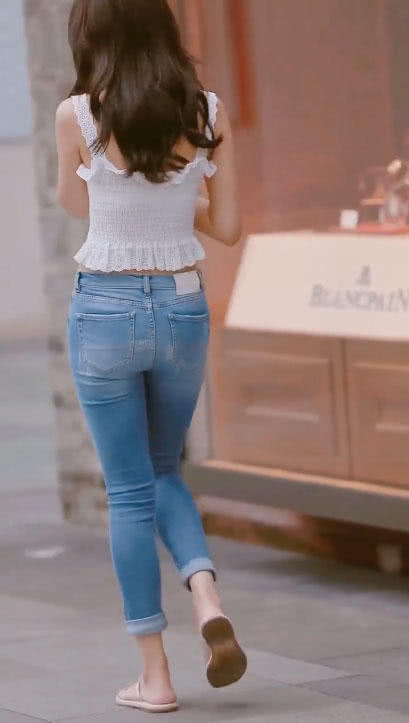 小姐姐白色吊带搭配紧身牛仔裤，立在人群中，显得如此特别