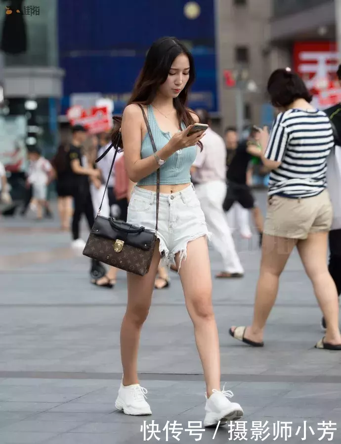 路人街拍，吊带上衣搭配白色热裤，展示性感好身材，时尚有魅力！