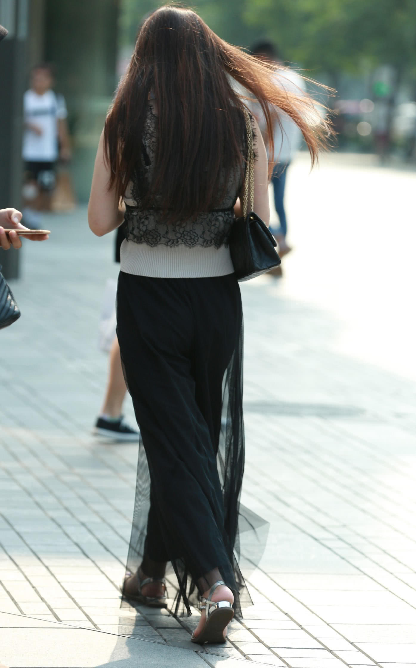 气质小姐姐秀发青丝随风飘动，全身散发着不一样的韵味