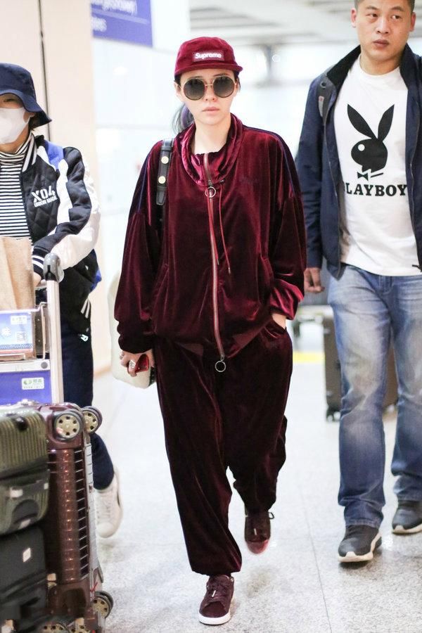 张靓颖机场秀从头到脚都是时下最潮的酒红色，网友:简直就是灾难
