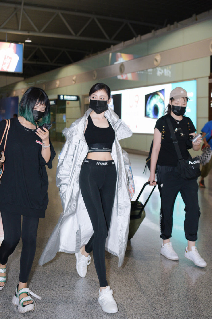 张天爱现身机场 黑色紧身裤外搭银色长款雨衣 尽显大长腿