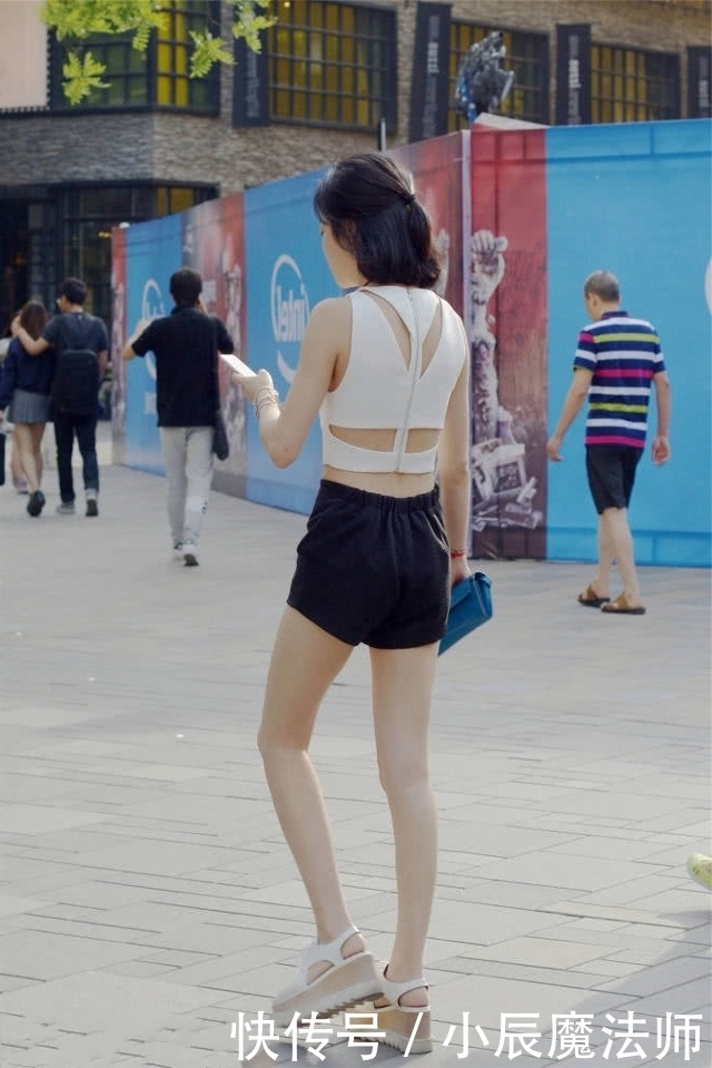 位小姐姐:路人街拍,美女穿白色的修身背心,很是吸睛呢