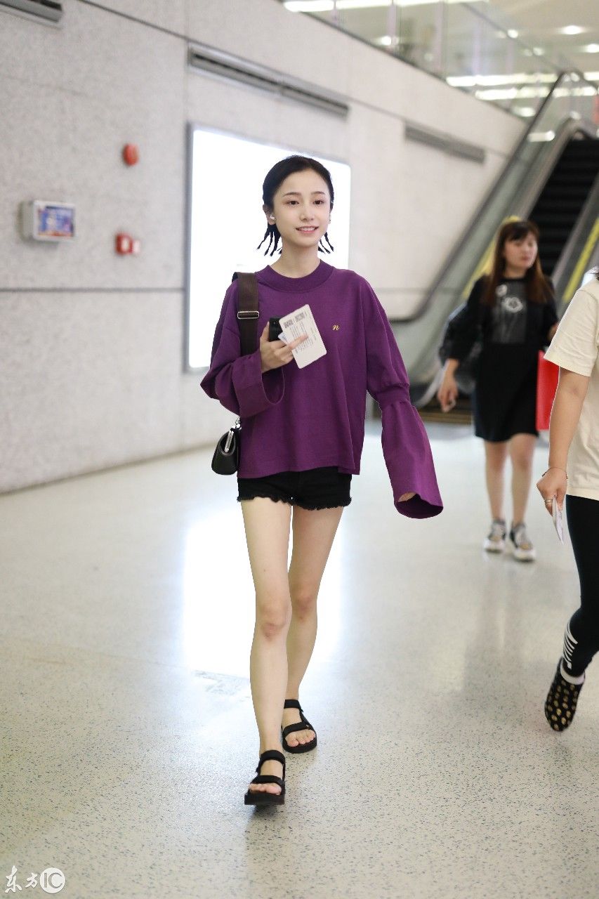 姜梓新穿紫色卫衣搭配黑短裤现身机场，皮肤白皙面带微笑大秀美腿