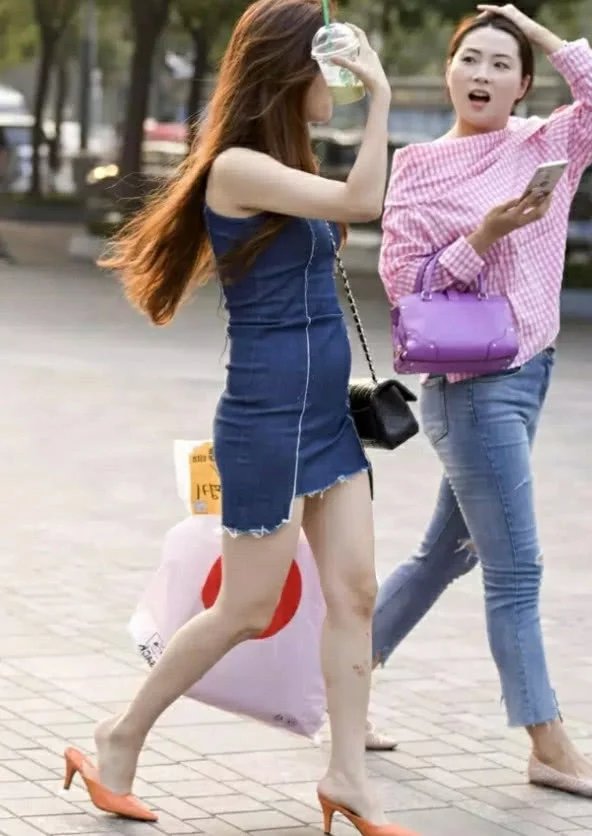 性感白富美小姐姐街头漫步，紧身短裙显诱人身姿，旁边的闺蜜成了