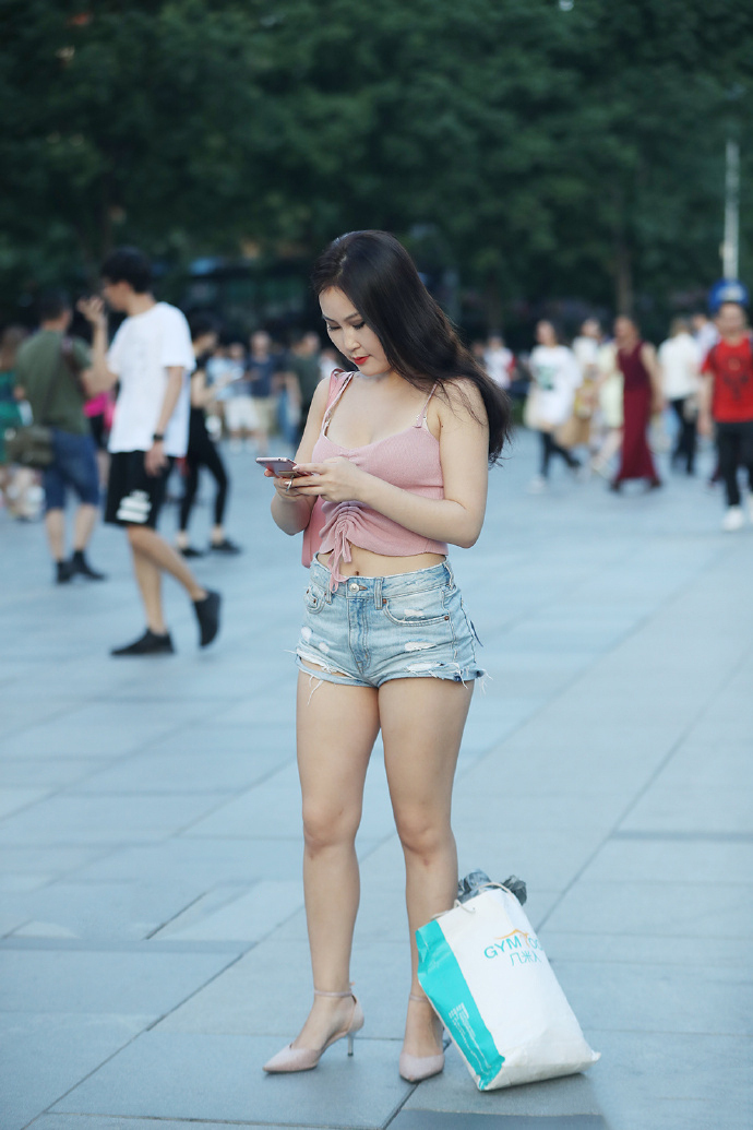 小姐姐身穿粉色吊带衣,手中的东西太重,弯腰放东西的姿态真美!