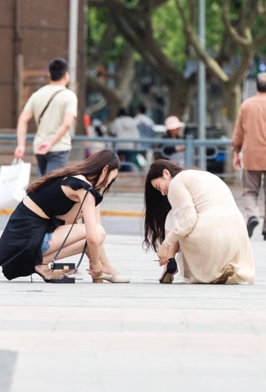 俏皮小姐姐嫌弃高跟鞋太高，与闺蜜当街换鞋，露出精美小脚丫