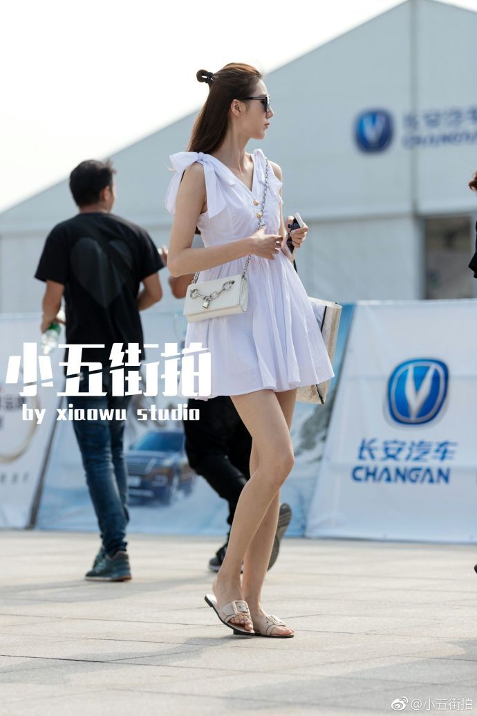 路人街拍：穿短裤白背心的小姐姐，双腿很白很美，背包很艺术