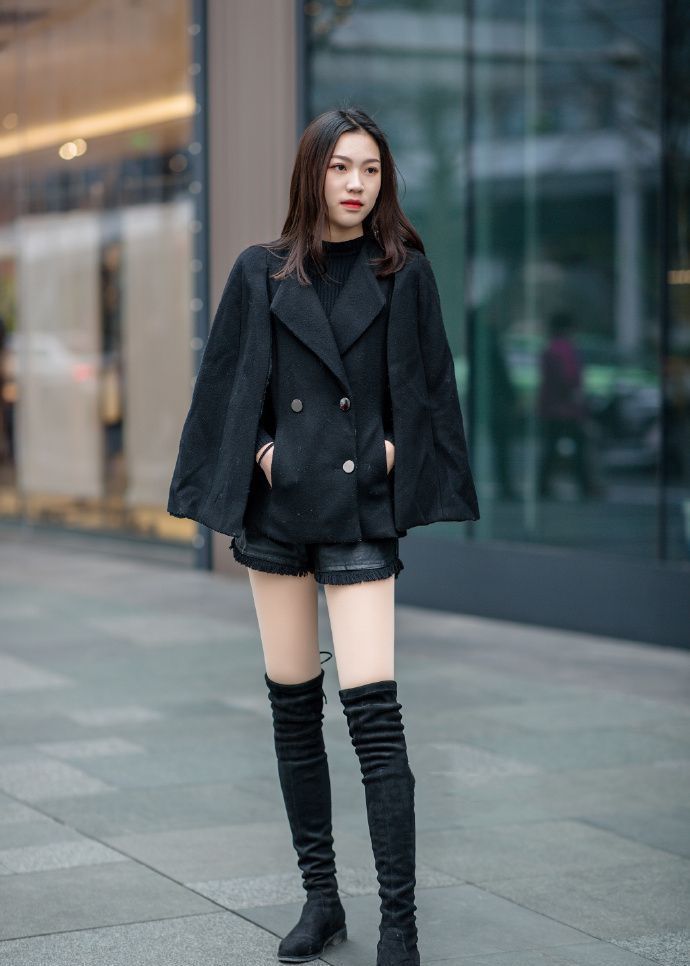 「小美女」街拍:一身黑色的服装,配上一双高筒的靴子,小美女高挑的身材让人羡慕
