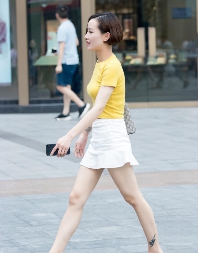 姐姐：小姐姐穿白色短裙，更加凸显苗条身材，路人街拍
