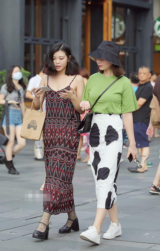 路人街拍，左边小姐姐穿的是一件印花的吊带连衣裙遮肉又显高