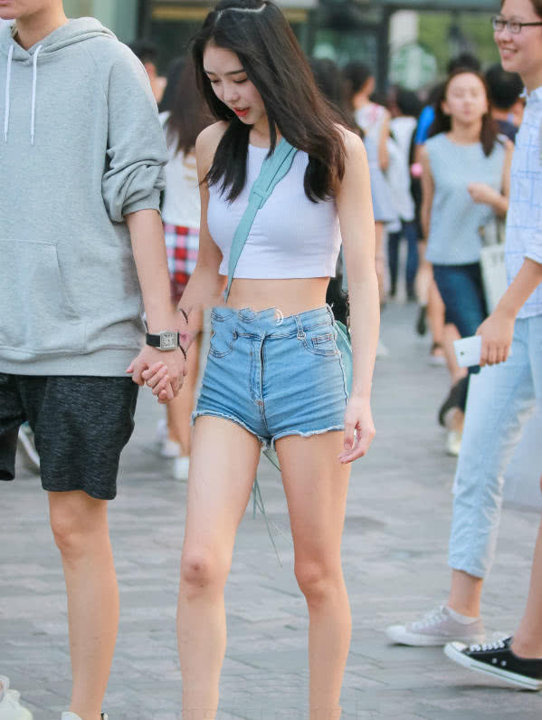 甜美小姐姐露脐装秀出白皙小蛮腰，超短裤裹出浑圆曲线，丸子头俏