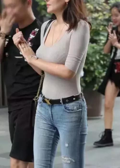 时尚小妈妈和男友逛街牛仔裤勾勒出了性感的身材，丰腴的上围
