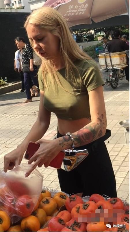 街拍:大街上买水果的外国妞，身材好，时尚感强