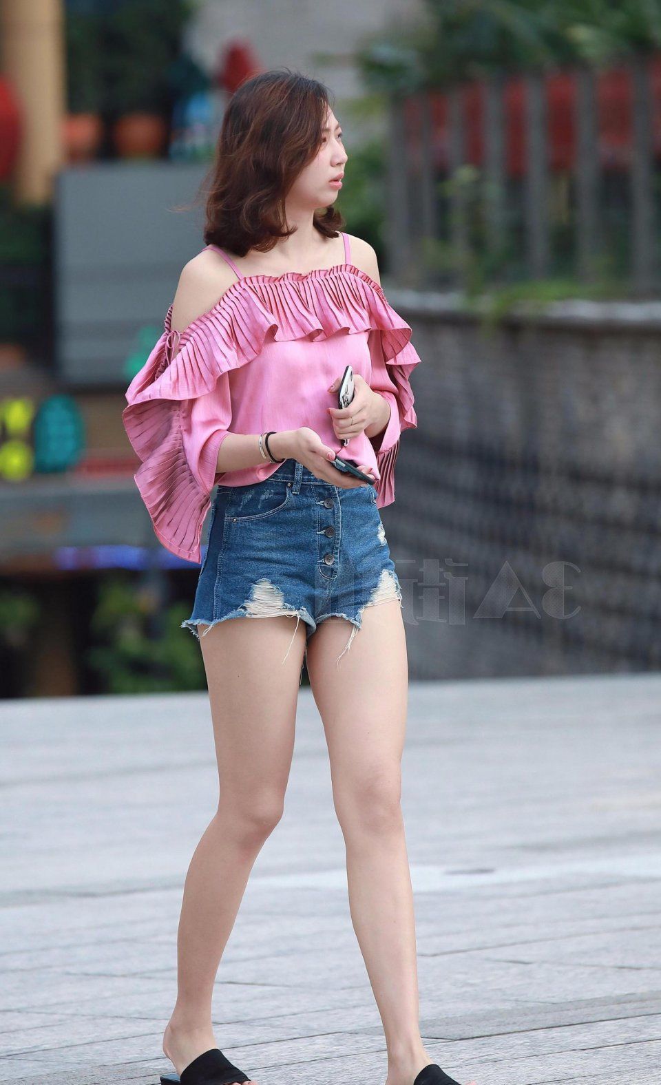 街拍美女:小姐姐牛仔短裤尽显修长美腿，玩起手机很优雅