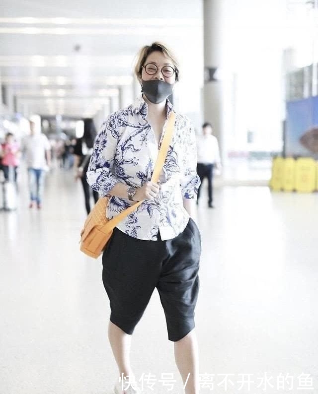 「显腿短」毛阿敏罕见现身机场,穿陶瓷衬衫配五分裤亮相,57岁素颜也不见老