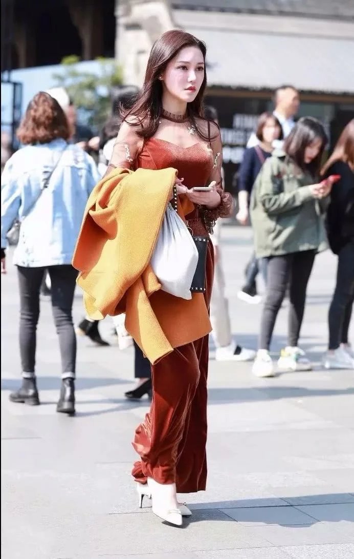 街拍身材饱满的性感美女，上身吊带的样子非常的性感迷人