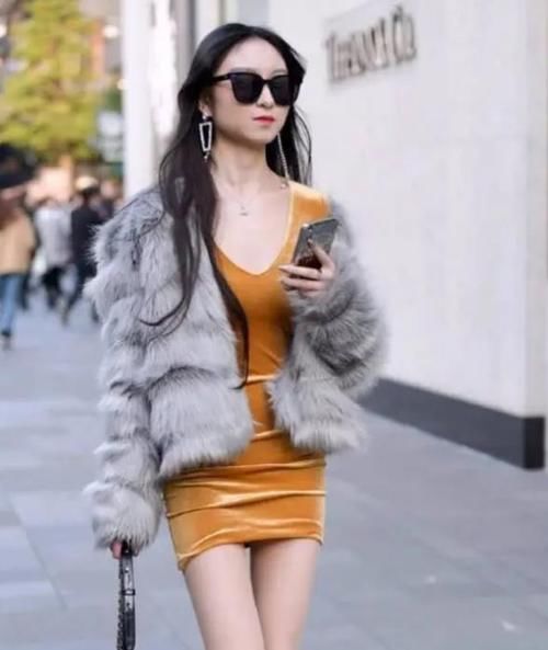  [连衣裙]潮范儿女神来了，街拍：幽韵撩人的美女，一件黄色连衣裙外搭皮草上衣，魅力十足