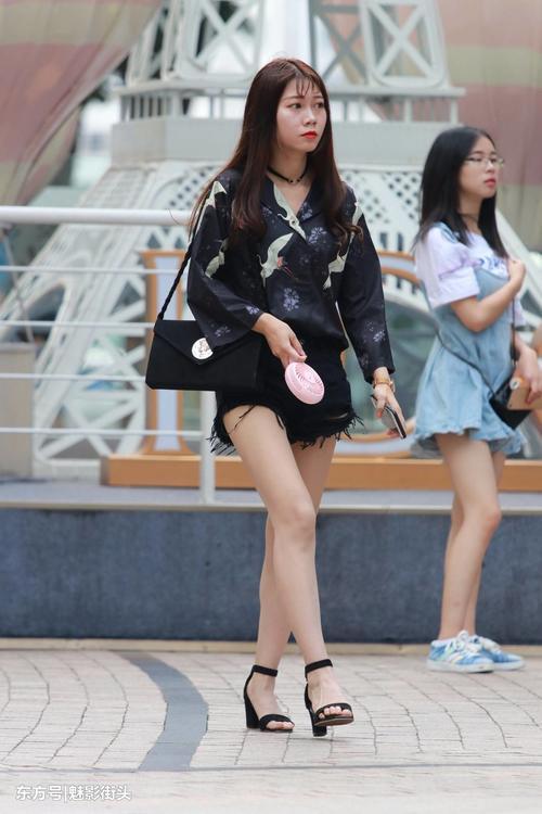 手拿风扇的长腿小姐姐，热裤配上高跟凉鞋让白嫩的双腿性感无比