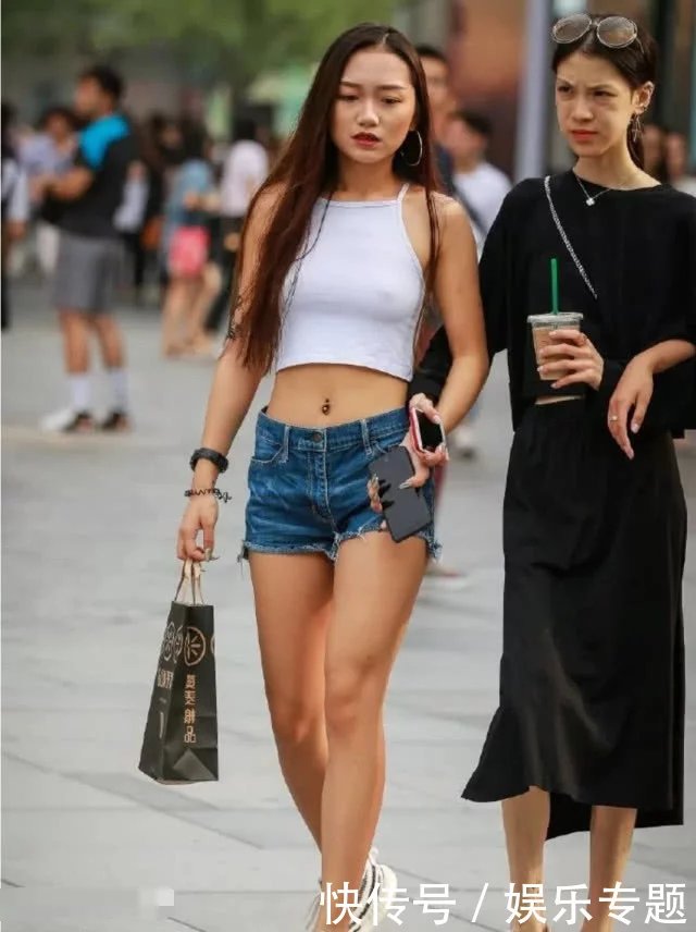 辣妹热裤秀笔直双腿和健美蛮腰，真空穿着背心，时尚又俏皮