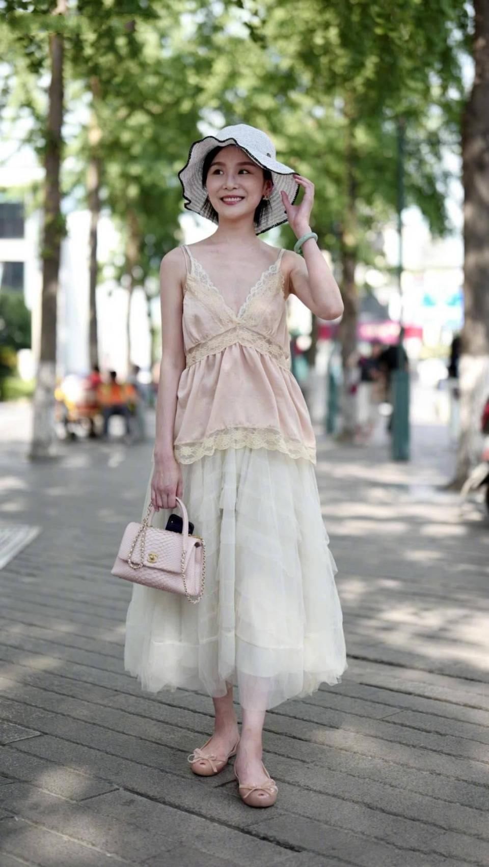 街拍:广场上的长裙小姐姐,用手遮阳,一脸的无可奈何?