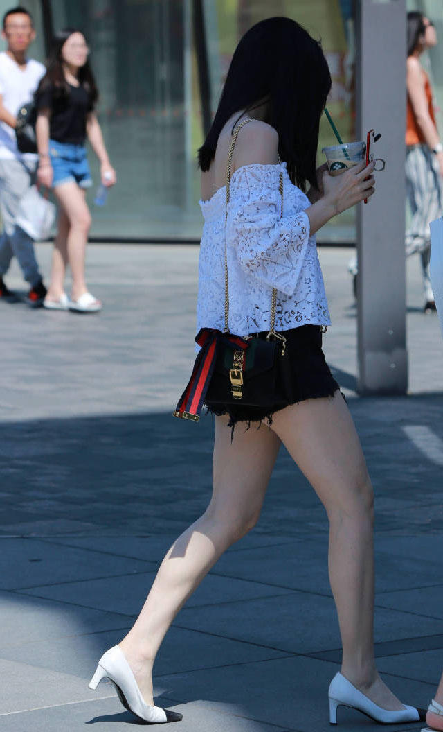 时尚姐妹花边喝奶茶边赶路，一个穿的像个围裙，一个镂空热裤大秀