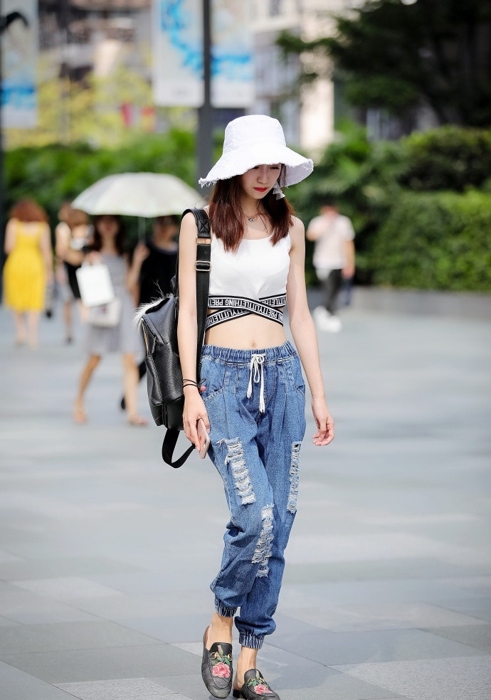 路人街拍：修身牛仔裤搭配露脐装很性感，皮肤白皙的小姐姐真美