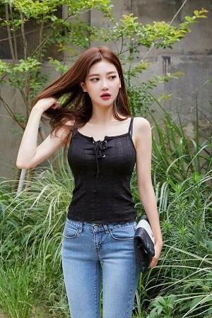 清新美女身穿吊带背心搭配牛仔裤，秀出漂亮的身材，非常有女人味